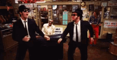 two men dancing in front of a help wanted sign