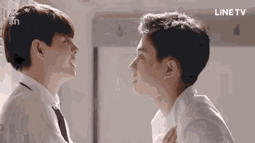 two men are standing next to each other and looking at each other in a room .