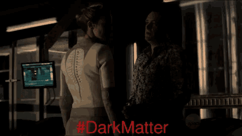 a man and a woman are standing next to each other with #darkmatter written in red