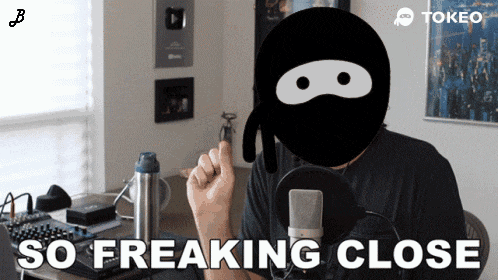 a man with a ninja mask on his face says " so freaking close " in front of a microphone