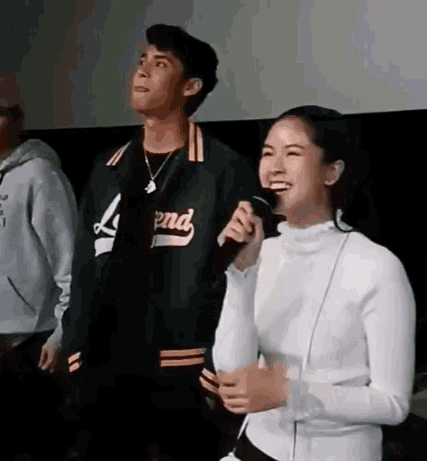 a man and a woman are standing next to each other in a room .