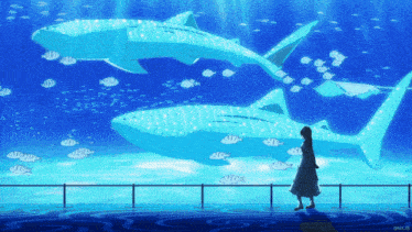 a woman stands in front of an aquarium with whale sharks in it