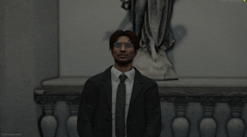 a man in a suit and tie stands in front of a statue with a loading screen displayed