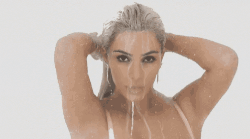 a woman is taking a shower with water coming out of her mouth and hair .