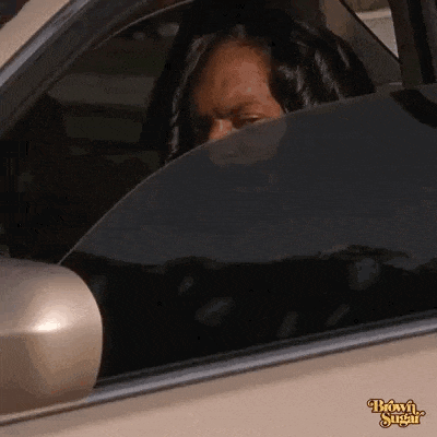 a woman is sitting in a car with her head out the window .