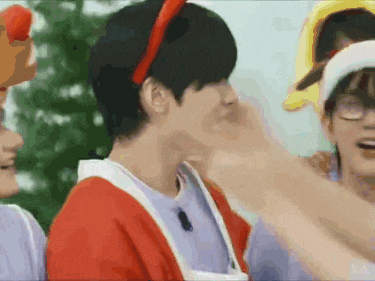 a man wearing a red headband and a white apron is being touched by another man .