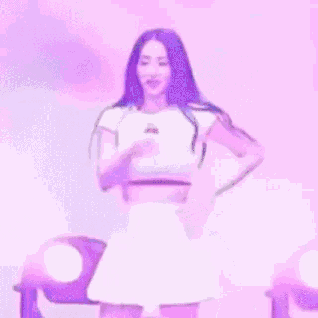 a woman is standing on a stage wearing a white skirt and a crop top with cherries on it .