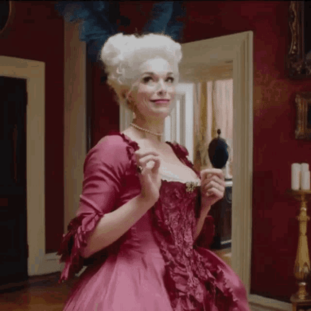 a woman in a red dress is holding a brush and smiling .