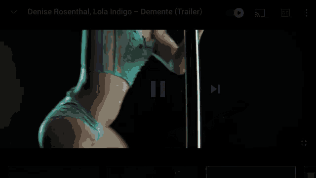 a woman in lingerie is dancing on a pole in a video .