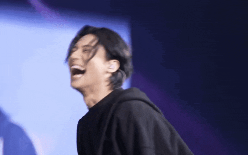 a man is laughing while standing on a stage .