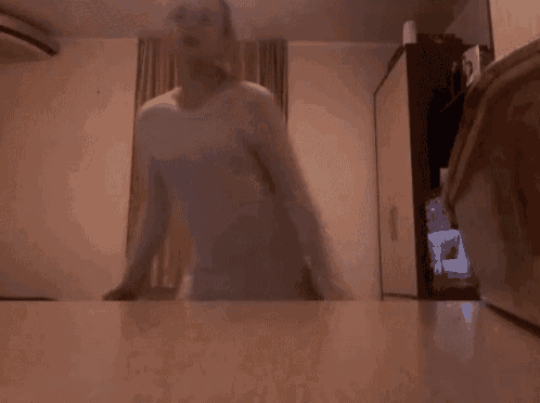 a woman in a white shirt and black pants is standing on a table