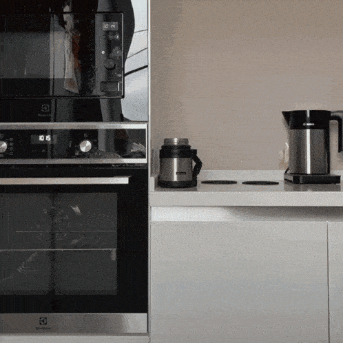 a kitchen with an electrolux oven and a stainless steel coffee pot