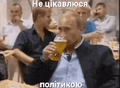 a man is drinking a glass of beer in front of a crowd .