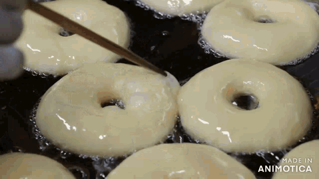 a bunch of donuts are being cooked in a frying pan and the words made in animatica are visible