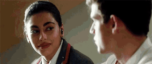 a man and a woman are looking at each other and the woman is wearing ear buds .