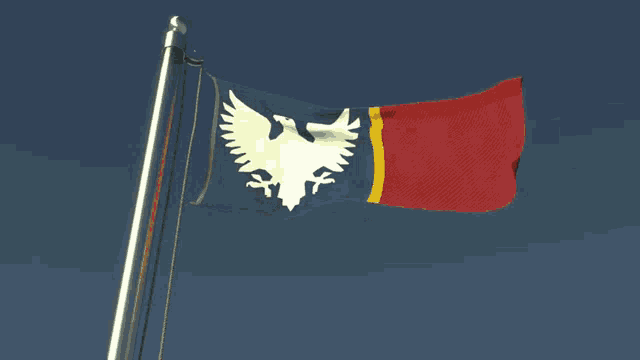 a flag with a white eagle on it is flying in the wind