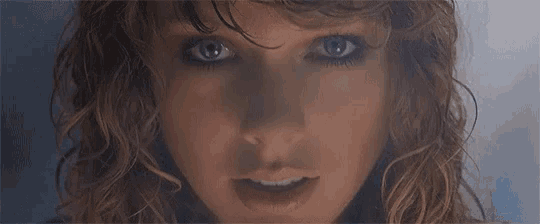 a close up of a woman with blue eyes and wet hair .