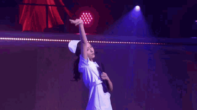 a woman in a nurse 's outfit is holding a folder on stage .