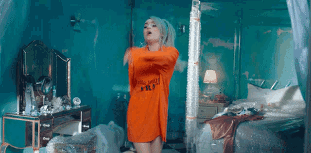 a woman wearing an orange shirt that says " whole world "