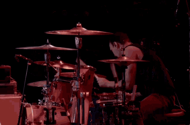 a man playing drums in front of a drum set that says ' drums ' on it