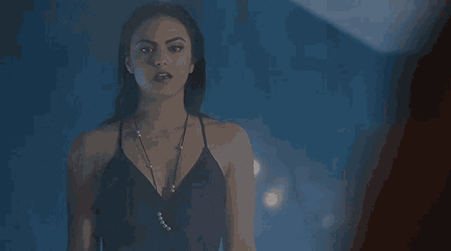 a woman in a black dress with pearls on the neckline