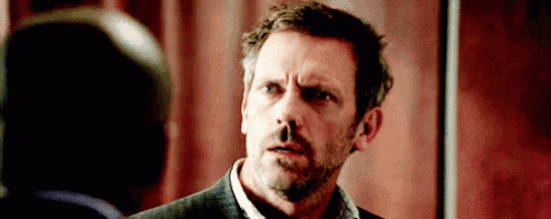 a man with a beard is making a funny face while looking at another man .