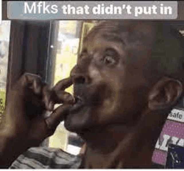 a man is smoking a cigarette and making a face .