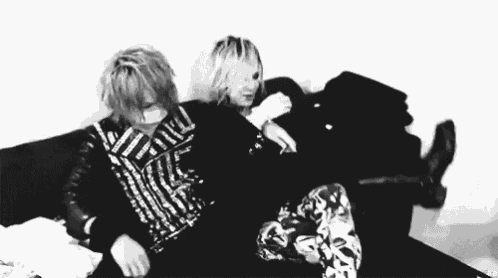 a couple of people are sitting on a couch and hugging each other .