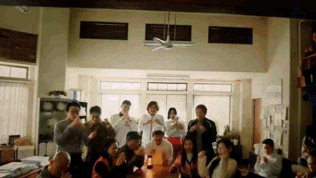 a group of people are dancing in a room with a lantern on the table