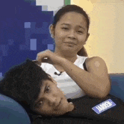 a woman is laying on a man 's lap on a couch .