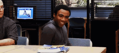 a man sits at a desk with books on it
