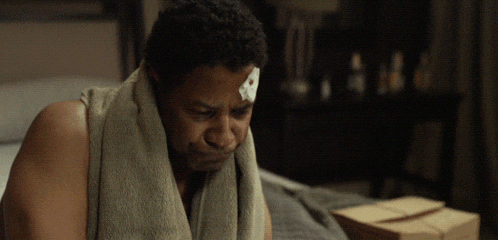 a man with a bandage on his forehead looks down
