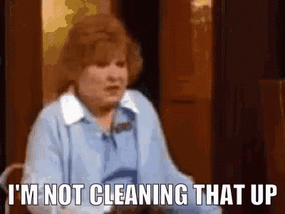 a woman in a blue shirt is sitting in a chair and says `` i 'm not cleaning that up '' .