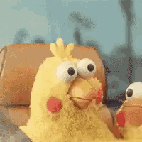 two stuffed chickens are sitting on a couch .