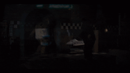 a man stands in a dark room next to a space shuttle display