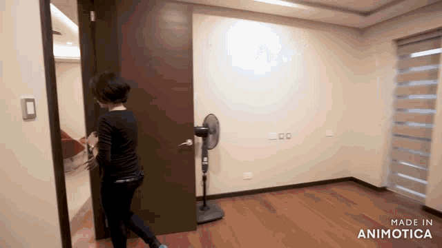 a woman opens a door in a room with the words made in animatica on the bottom