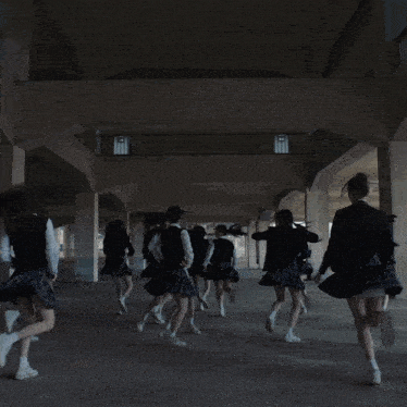 a girl in a school uniform is dancing with her hands in the air