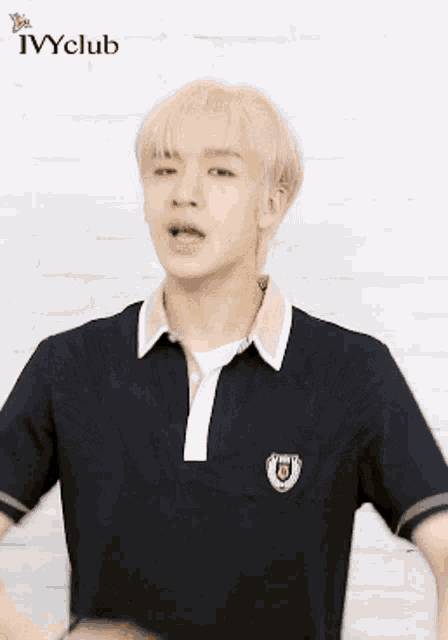 a young man wearing a black polo shirt with ivy club embroidered on the front