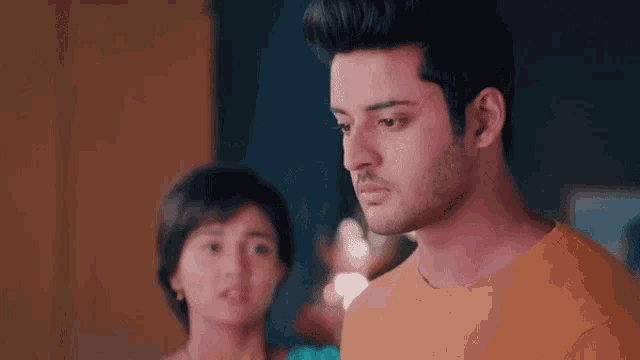 a man and a woman are looking at each other in a room .