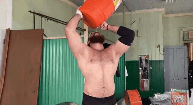 a man is holding an orange cooler over his head