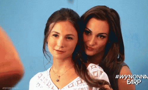 two women are posing for a picture with the hashtag wynonna earp on the bottom