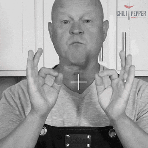 a man wearing an apron with the word chili pepper on the top