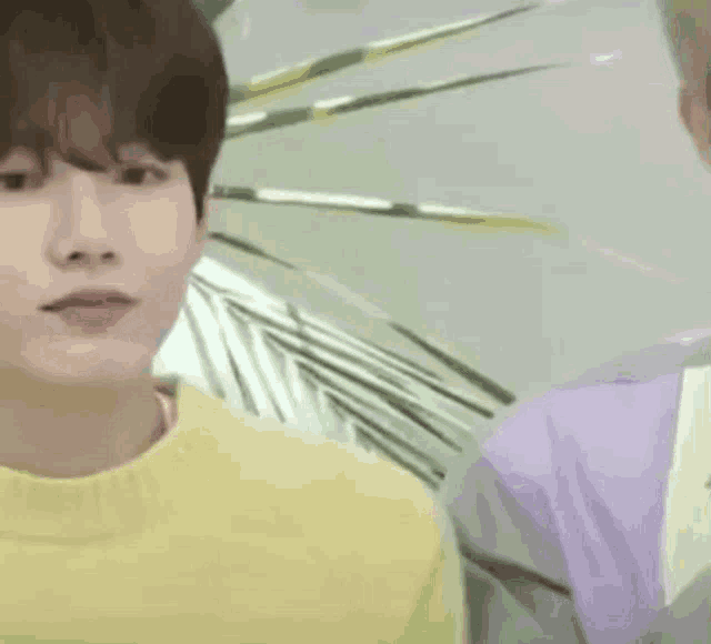 a man in a yellow sweater is sticking out his tongue .