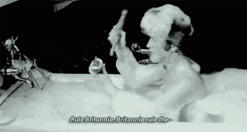 a man is taking a bath in a bathtub with foam on his head and shaving his face .
