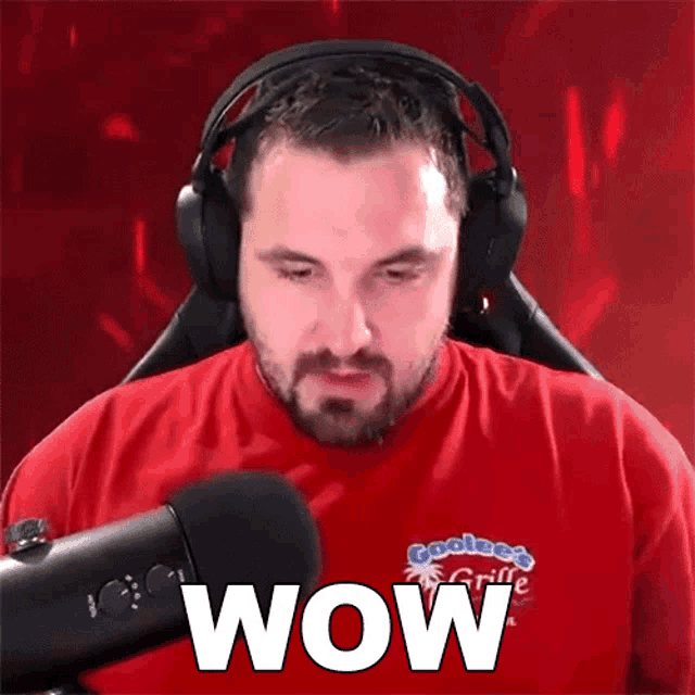a man wearing headphones and a red shirt with the word wow written on it