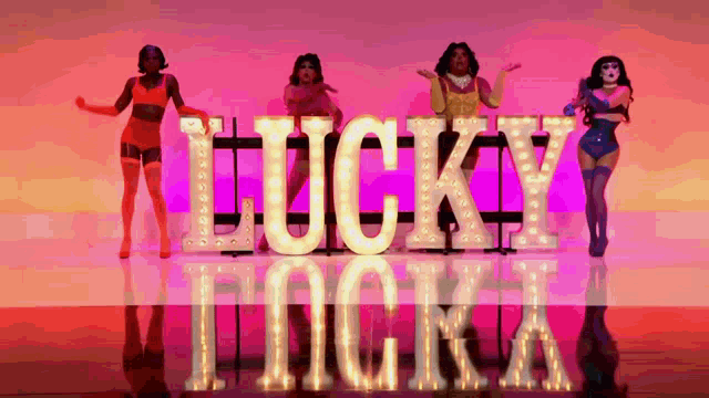 a group of drag queens are dancing in front of a sign that says lucky lucka