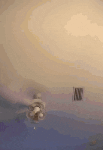 a ceiling fan is spinning on a ceiling in a room