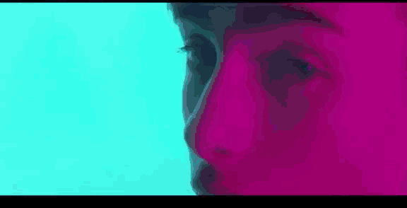 a close up of a person 's face with a blue and purple background .