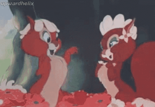a couple of red squirrels are standing next to each other in a field of red flowers .