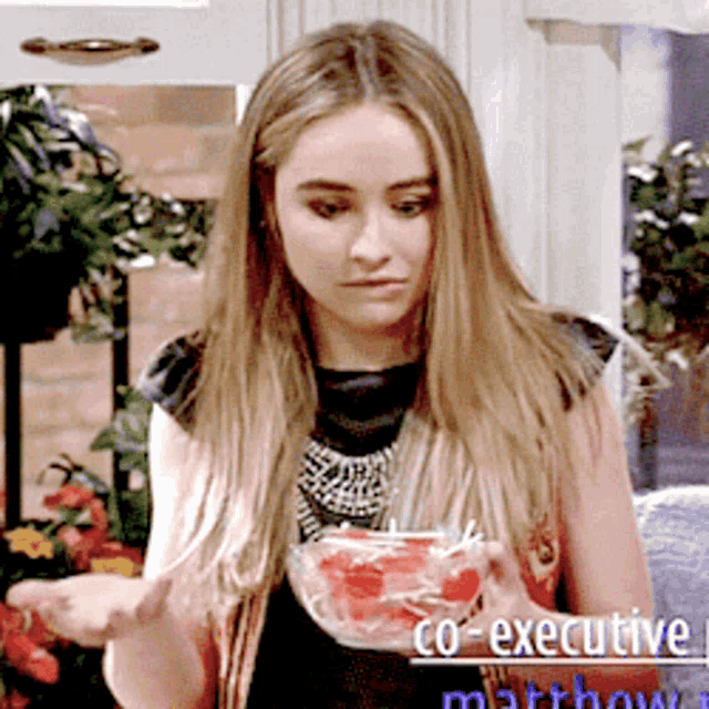 a woman is holding a bowl of watermelon with the words co-executive matthew on the bottom